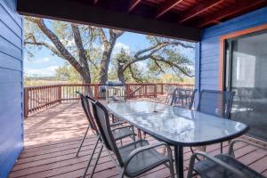 a patio with a table and chairs on a deck at Bee Happy at the Lake in Canyon Lake