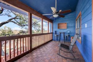 a screened in porch with a ceiling fan and chairs at Bee Happy at the Lake in Canyon Lake