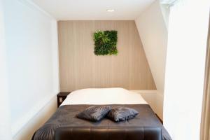 a bedroom with a bed with a plant on the wall at Hotel WILL Kashiwa in Kashiwa
