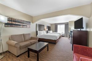 a large hotel room with a bed and a couch at Best Western Plus Capital Inn in Jefferson City