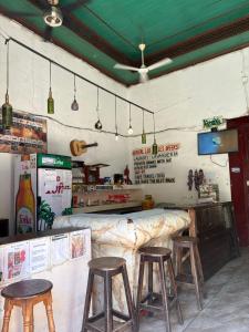a restaurant with three stools and a bar in a room at Hostal Los Cheles in León