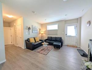 a living room with a couch and a table at Villa Meadows Lethbridge in Lethbridge