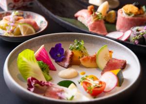 a bowl of food with fruits and vegetables on a table at Yufuin Hotel Shuhokan in Yufu