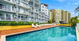 a swimming pool in front of some apartment buildings at Zen Marina Studio: bayview - shared pool - central in Larrakeyah +13 photos