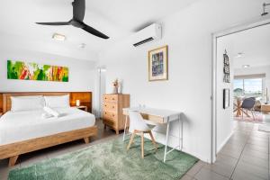 a bedroom with a bed and a desk and a table at Zen Marina Studio: bayview - shared pool - central in Larrakeyah
