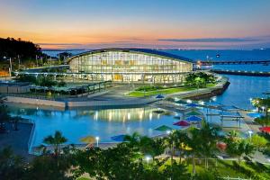 a building with a pool in front of the water at Zen Marina Studio: bayview - shared pool - central in Larrakeyah