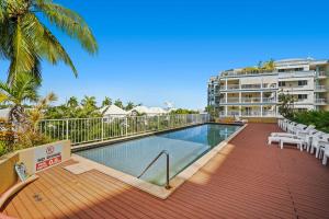 a swimming pool on a deck next to a building at Zen Marina Studio: bayview - shared pool - central in Larrakeyah