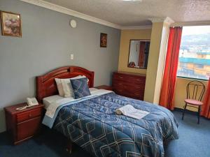 a hotel room with a bed and a window at Hotel Allegria in Quito