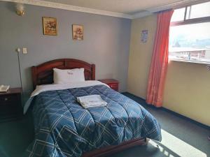 a bedroom with a bed and a window at Hotel Allegria in Quito +5 photos