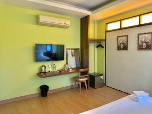 a room with a desk and a television on a wall at Excellence Pool Villa in Na Jomtien