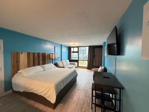 a bedroom with a bed and a blue wall at Single, Double or Quad Oceanview Studios - Direct Beach Access, Oceanfront Pool & Tiki in Daytona Beach Shores +104 photos