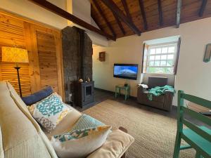a living room with a couch and a tv at Casa do Laureano in Santo Amaro