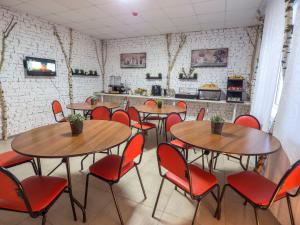 ロブニャにあるL-Apartのテーブルと赤い椅子が備わるレストラン