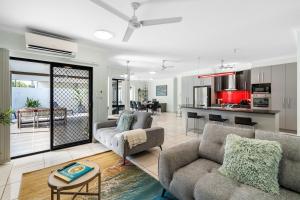 a living room with two couches and a kitchen at Zen Orient Luxurious 4BR Oasis with Private Pool in Leanyer