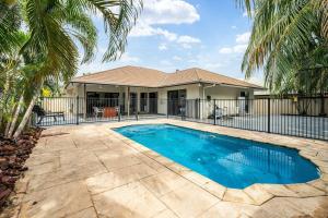 a swimming pool in front of a house at Zen Orient Luxurious 4BR Oasis with Private Pool in Leanyer