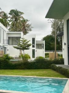 a house with a swimming pool in front of a house at Meet Up Villa in Ban Nai Khao