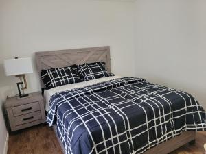 a bedroom with a bed with a blue and white comforter at Executive Cozy 2bedroom Basement Suite in Brandon