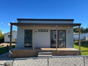 a tiny house sitting on top of a porch at The Crib on Leven in Naseby +4 photos