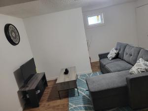 a living room with a couch and a table at Executive Cozy 2bedroom Basement Suite in Brandon +2 photos