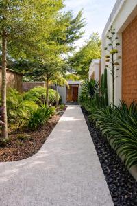a walkway in front of a house with trees at Pandan Bungalows in Selong Belanak