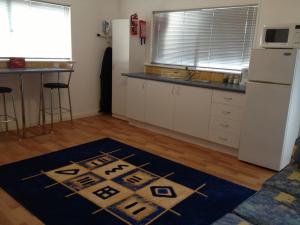 a kitchen with white cabinets and a blue rug on the floor at Redtail Cottages in Hester