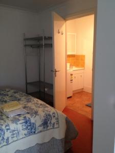 a bedroom with a bed and a bathroom with a sink at Redtail Cottages in Hester