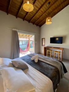 a bedroom with a large bed and a window at Morada Carmem in Praia do Rosa