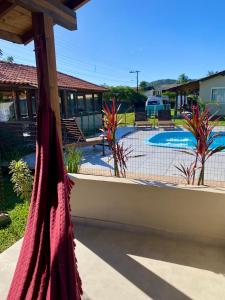 a patio with a hammock and a swimming pool at Morada Carmem in Praia do Rosa +9 photos