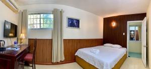 a bedroom with a bed and a desk and a window at Lam Son Hotel in Vung Tau +81 photos