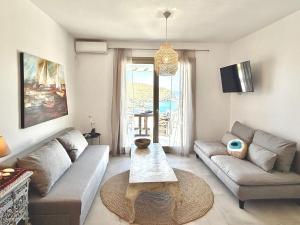 a living room with a couch and a table at Miramare Suites Mykonos in Merchia Beach