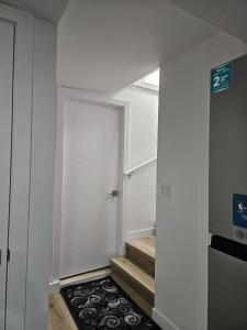a hallway with a door and stairs with a sign at Transcona Stay in Winnipeg