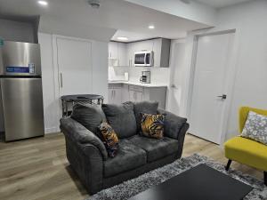 a living room with a couch and a kitchen at Transcona Stay in Winnipeg