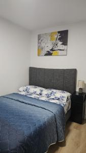 a bedroom with a bed and a painting on the wall at Transcona Stay in Winnipeg
