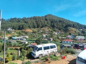 a white van parked in front of a mountain at Oneli Homestay in Nuwara Eliya