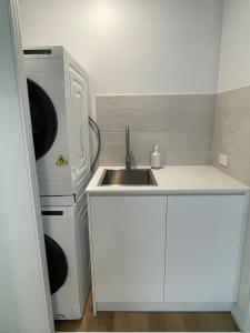 a small kitchen with a sink and a refrigerator at Silver Sands Villa in Mandurah