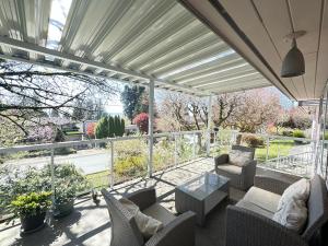 a patio with chairs and tables and a view of a garden at Joe West Vancouver Lodge in West Vancouver