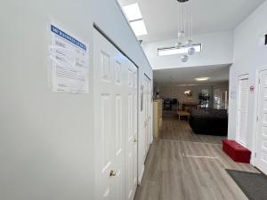 a hallway with white doors and a living room at Joe West Vancouver Lodge in West Vancouver