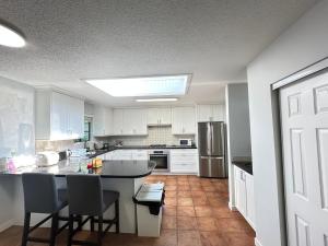 a kitchen with white cabinets and a table and chairs at Joe West Vancouver Lodge in West Vancouver +2 photos