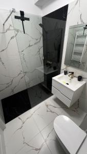a white bathroom with a sink and a mirror at Apartament excepțional Ramona in Râmnicu Vâlcea