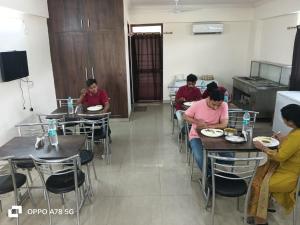 a group of people sitting at tables in a restaurant at Hotel Mittal Tower in Jhājra