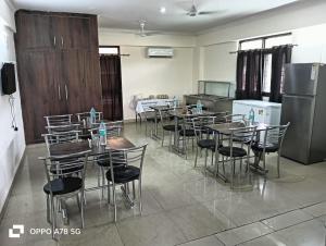 a group of tables and chairs in a room at Hotel Mittal Tower in Jhājra