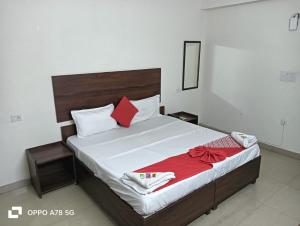 a bedroom with a large bed with red pillows at Hotel Mittal Tower in Jhājra +17 photos