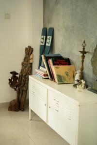 a white cabinet with books on top of it at Idam Villa in Akmimana