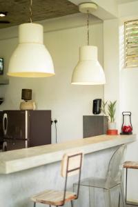 a kitchen with two white pendant lights and a counter at Idam Villa in Akmimana