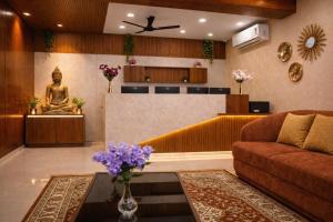 a living room with a couch and a statue at Grand Maalyasa Hotel and Suites, US Consulate Hyderabad 2 Mins walk in Hyderabad