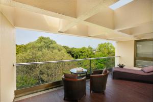 a room with a balcony with a table and chairs at Oakwood Residence Naylor Road Pune in Pune