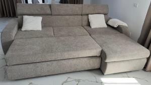 a brown couch with two pillows on top of it at Apartament excepțional Ramona in Râmnicu Vâlcea