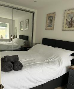 a bedroom with a white bed with towels on it at Tyddyn Serri in Rhosneigr