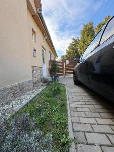 a car parked next to a house with a driveway at Ica Vendégház in Süttő