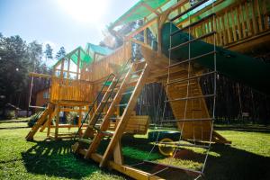 a wooden playground with a slide in the grass at Park Hotel Borvikha in Pilichki
